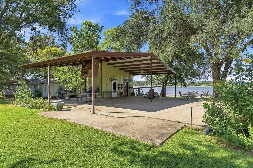 18404 Pine Drive, Eustace, TX 75124 Expansive covered patio with concrete flooring, open-air structure, and water frontage
