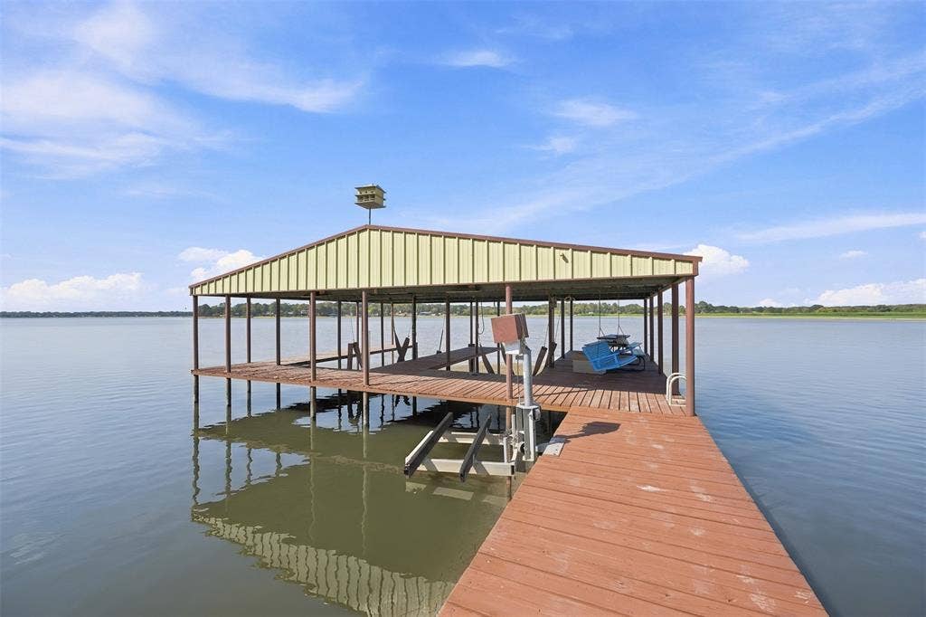 18404 Pine Drive, Eustace, TX 75124 Wood-finish boat dock with a covered slip, metal roof, and integrated boat lift