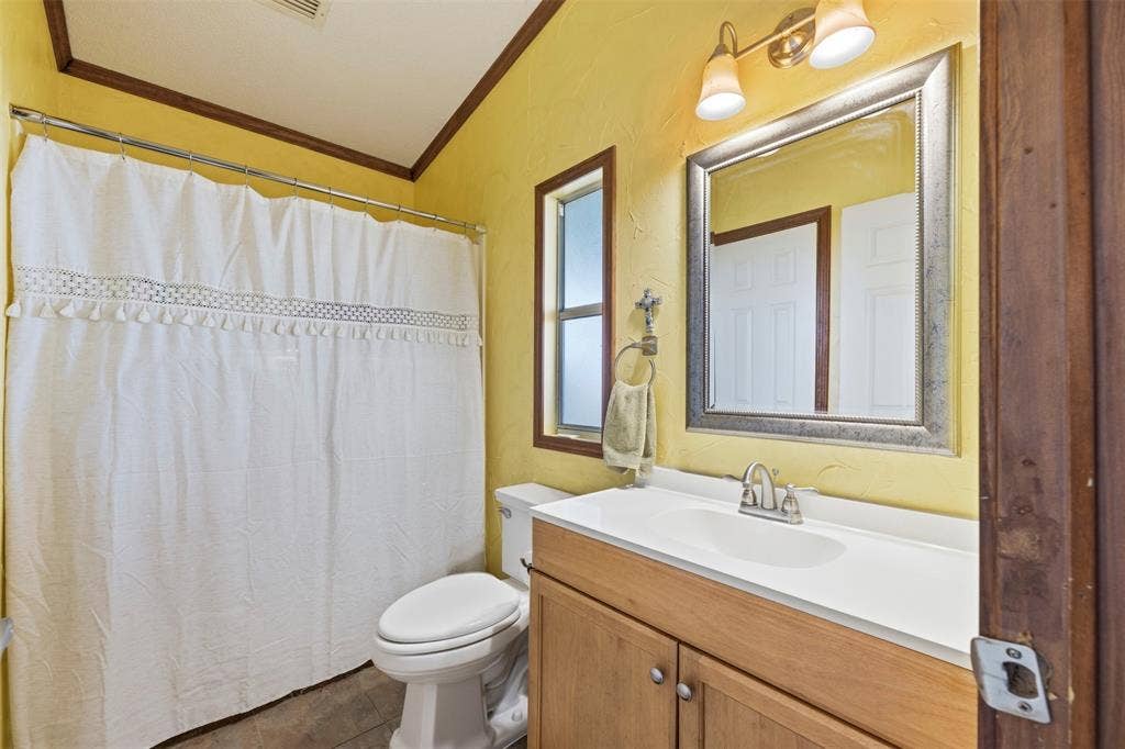 18404 Pine Drive, Eustace, TX 75124 Vanity with integrated sink, two-light fixture, framed mirror, and a window