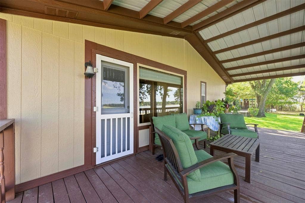 18404 Pine Drive, Eustace, TX 75124 Expansive covered porch featuring a wood deck, exposed beam ceiling, and a screen door