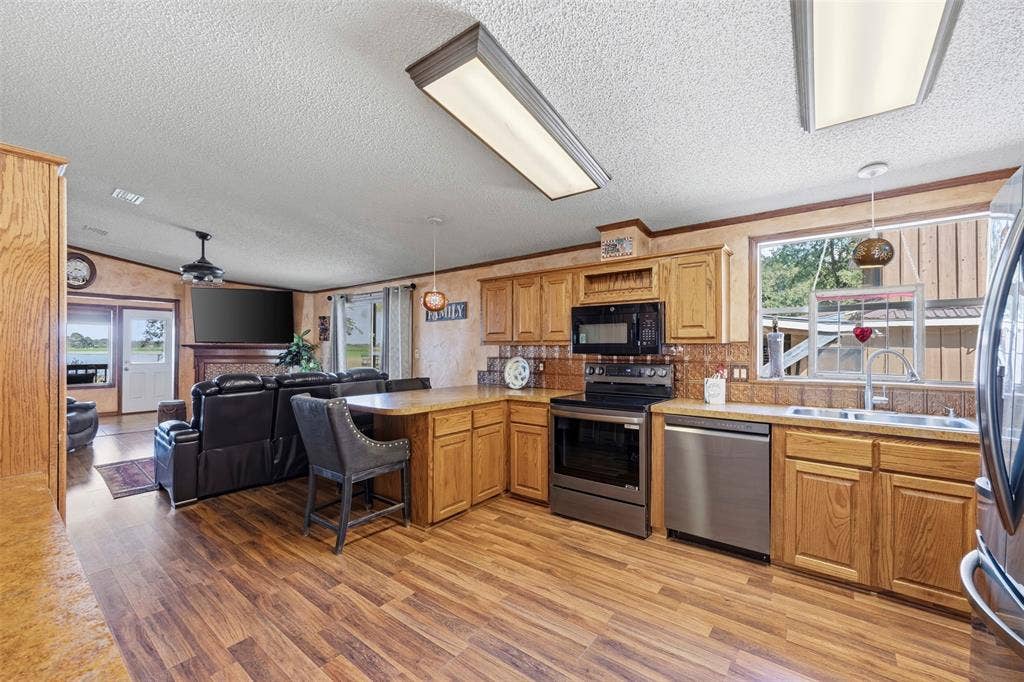 18404 Pine Drive, Eustace, TX 75124 Open-concept kitchen featuring wood-finish flooring, stainless steel appliances, and wood cabinetry