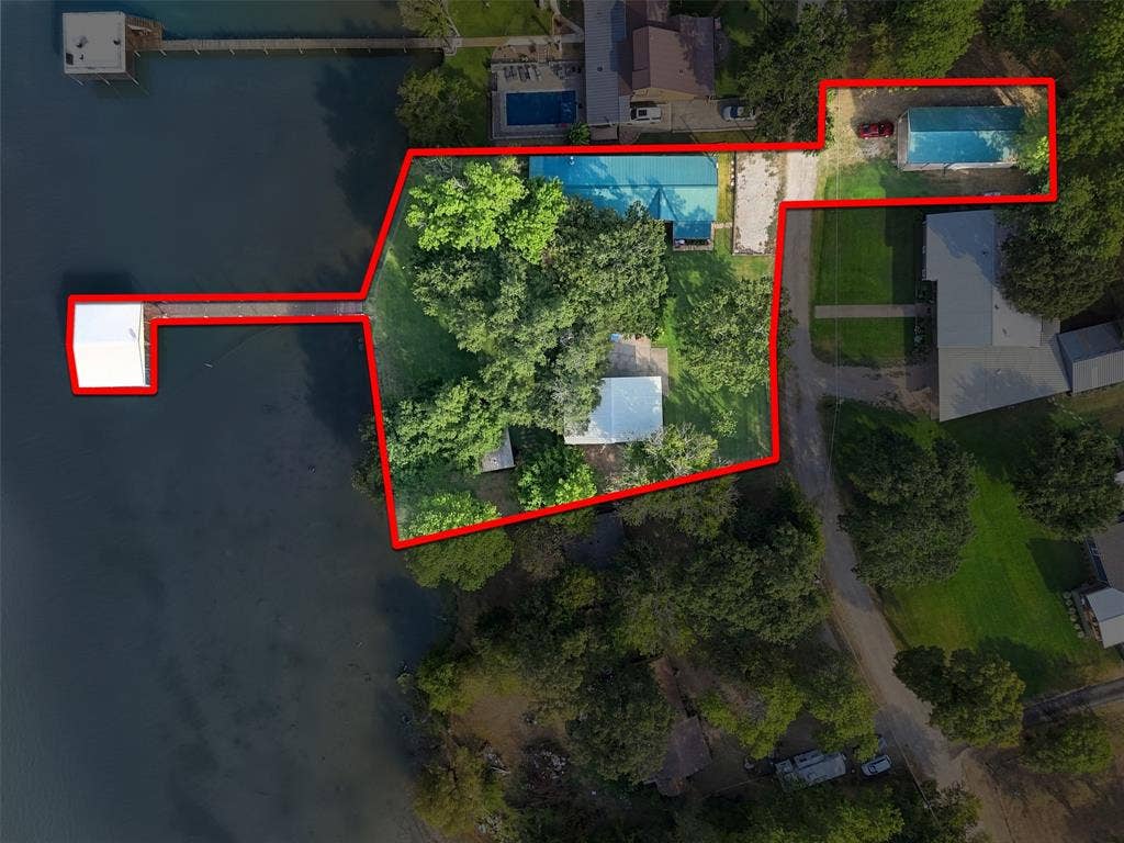 18404 Pine Drive, Eustace, TX 75124 Waterfront property with extensive boat dock, covered boat slip, mature trees, and a separate detached building