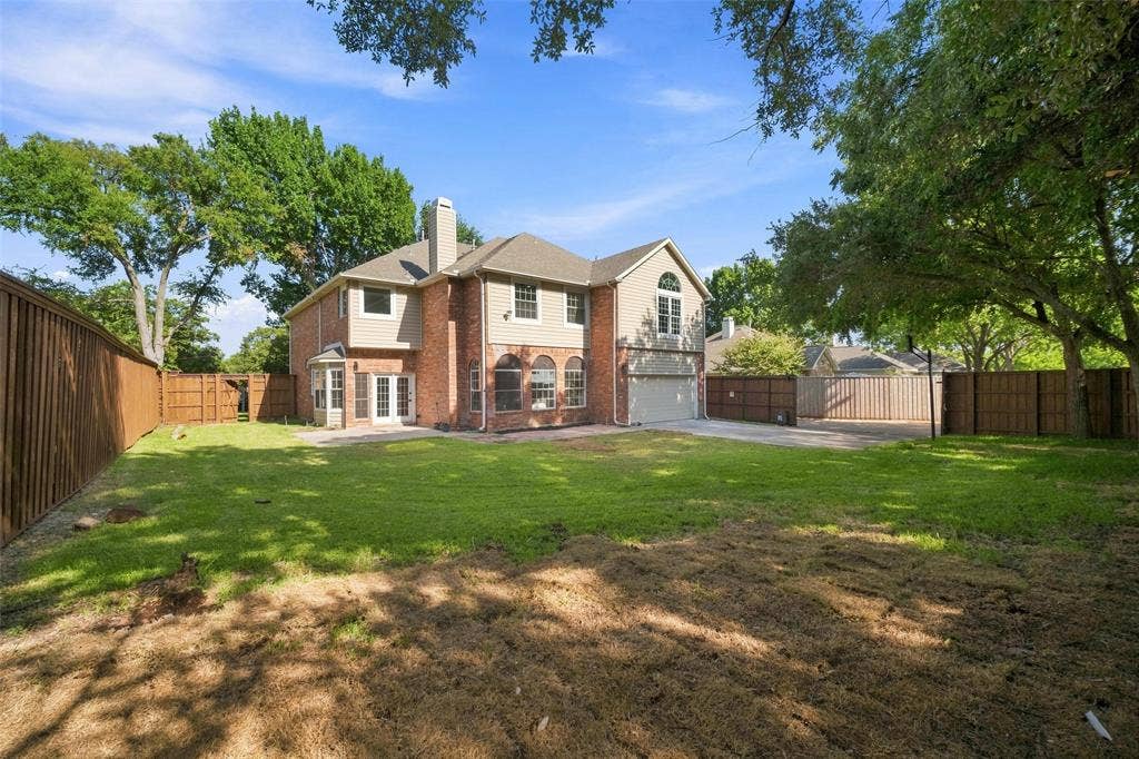 3041 Hillingdon Drive, Richardson, TX 75082 Expansive backyard featuring a manicured lawn, full privacy fencing, mature trees, and a brick and siding exterior