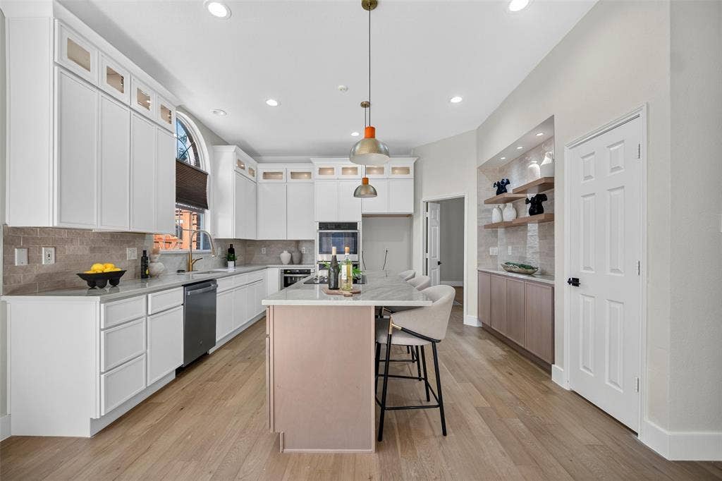 3041 Hillingdon Drive, Richardson, TX 75082 Spacious kitchen featuring white cabinetry, light wood-finish flooring, a center island with seating, a built-in oven, and recessed lighting