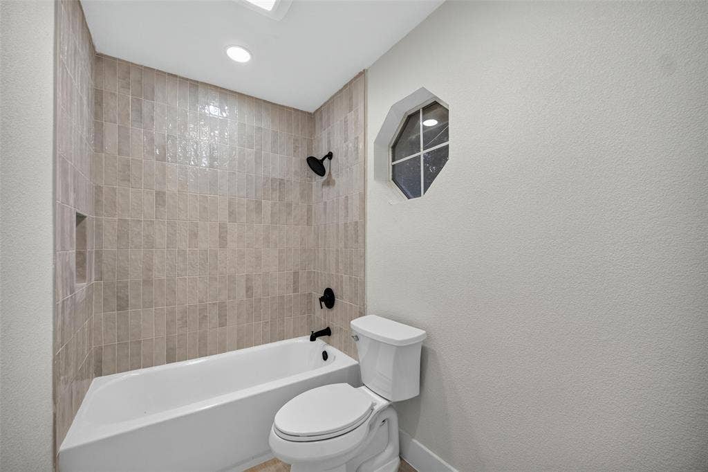 3041 Hillingdon Drive, Richardson, TX 75082 Bathtub with tiled surround, recessed shower niche, and matte black fixtures