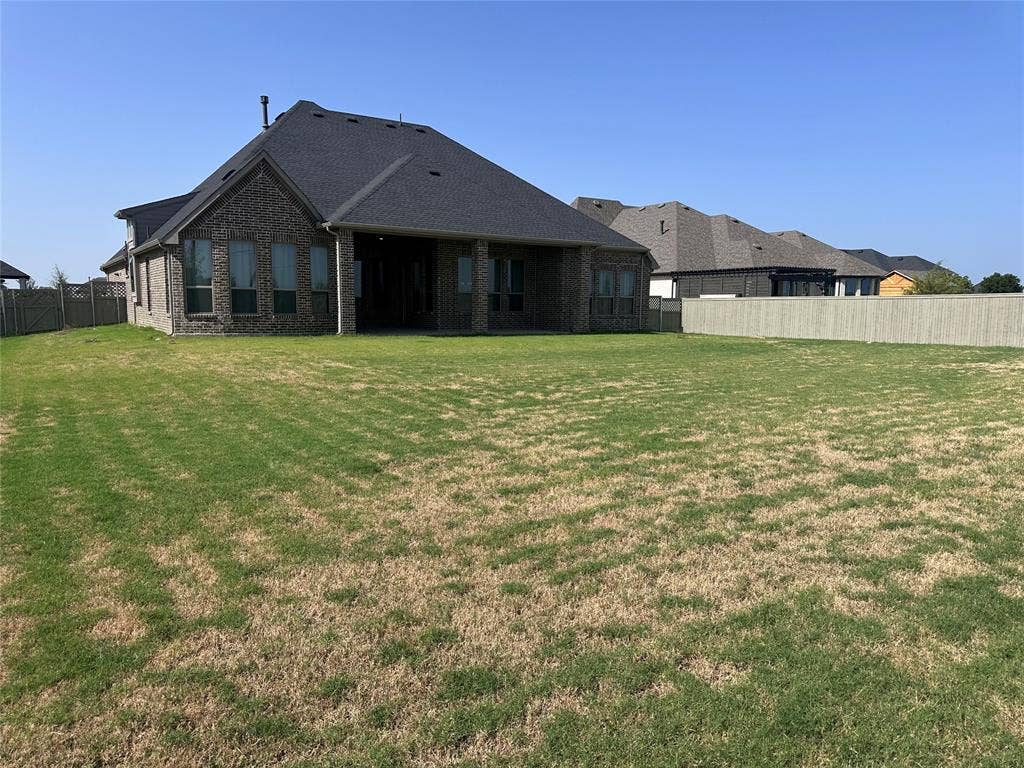 2608 Roaming Trail, Northlake, TX 76247 Expansive backyard featuring a privacy fence and a brick exterior with multiple windows