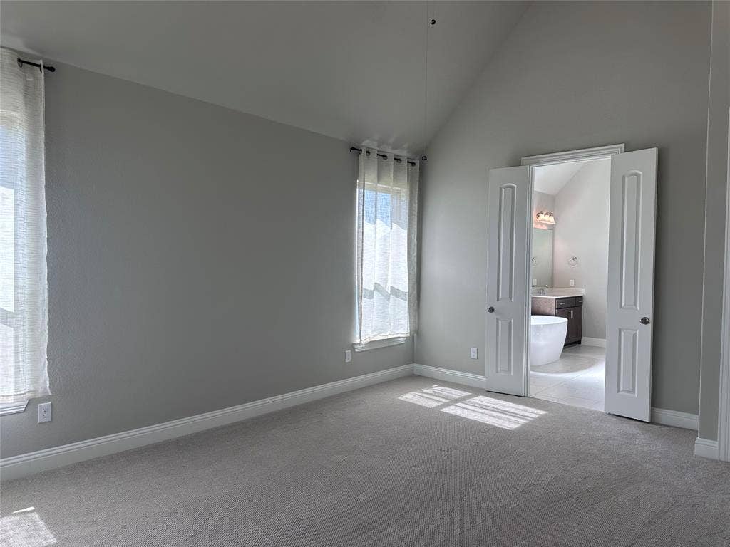 2608 Roaming Trail, Northlake, TX 76247 Vaulted ceiling room with dual windows, neutral wall tones, and plush carpeting