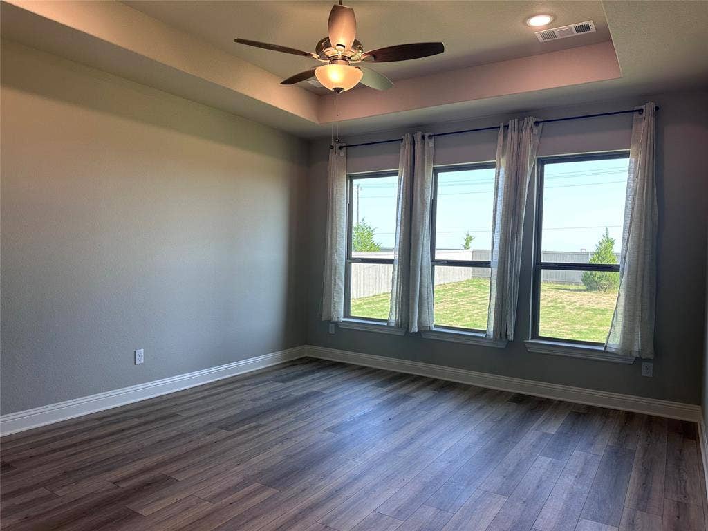 2608 Roaming Trail, Northlake, TX 76247 Tray ceiling with recessed lighting, ceiling fan with integrated light, wood-finish flooring, and multiple windows