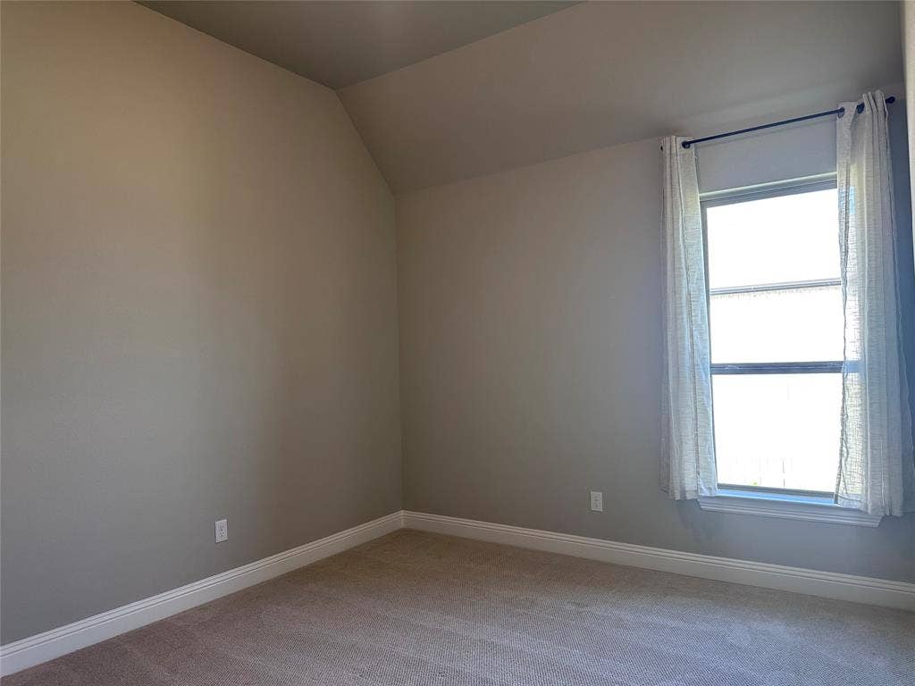 2608 Roaming Trail, Northlake, TX 76247 Neutral paint palette with sloped ceiling, carpeted flooring, and a window with white trim
