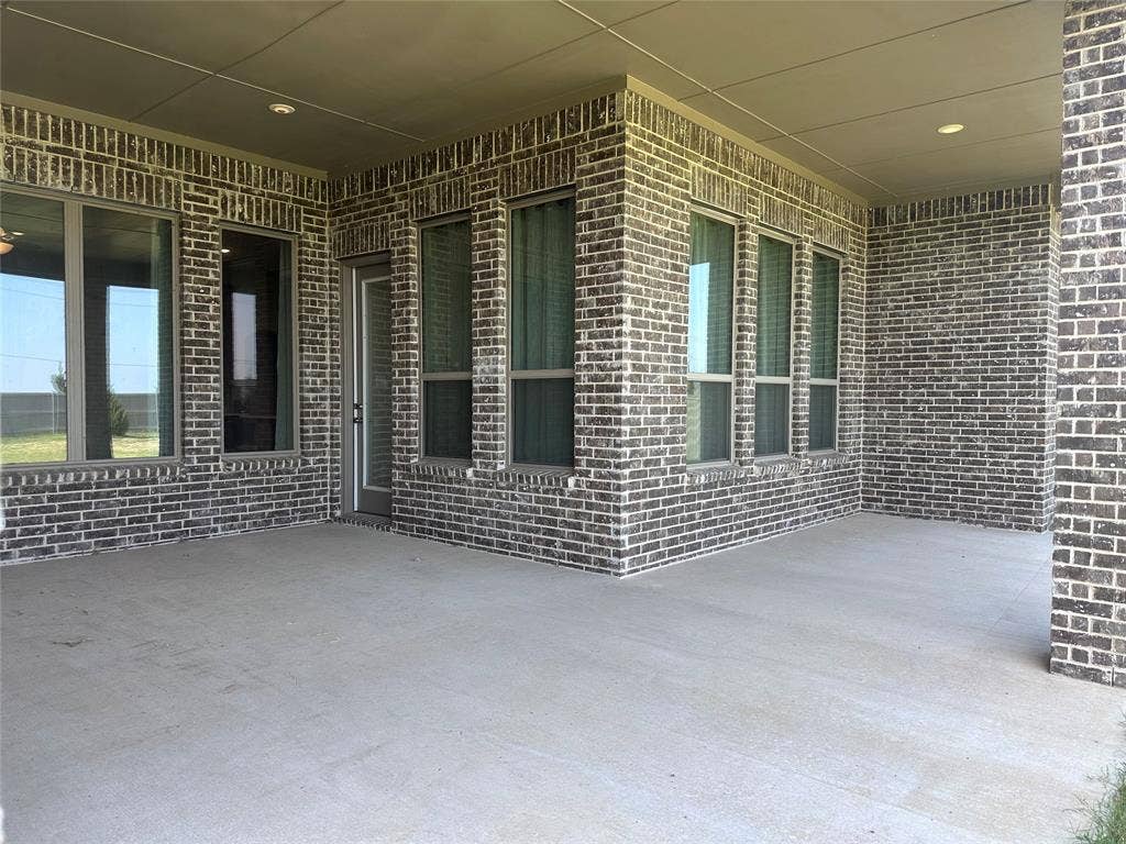 2608 Roaming Trail, Northlake, TX 76247 Covered patio with a concrete surface, brick exterior, multiple windows, and recessed lighting