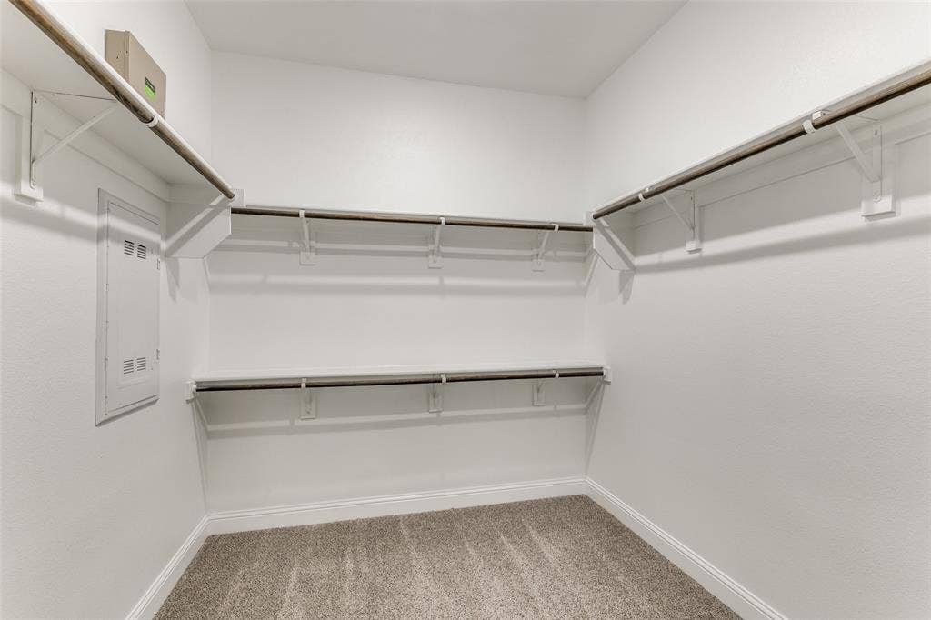 Spacious closet with light carpet and electric panel