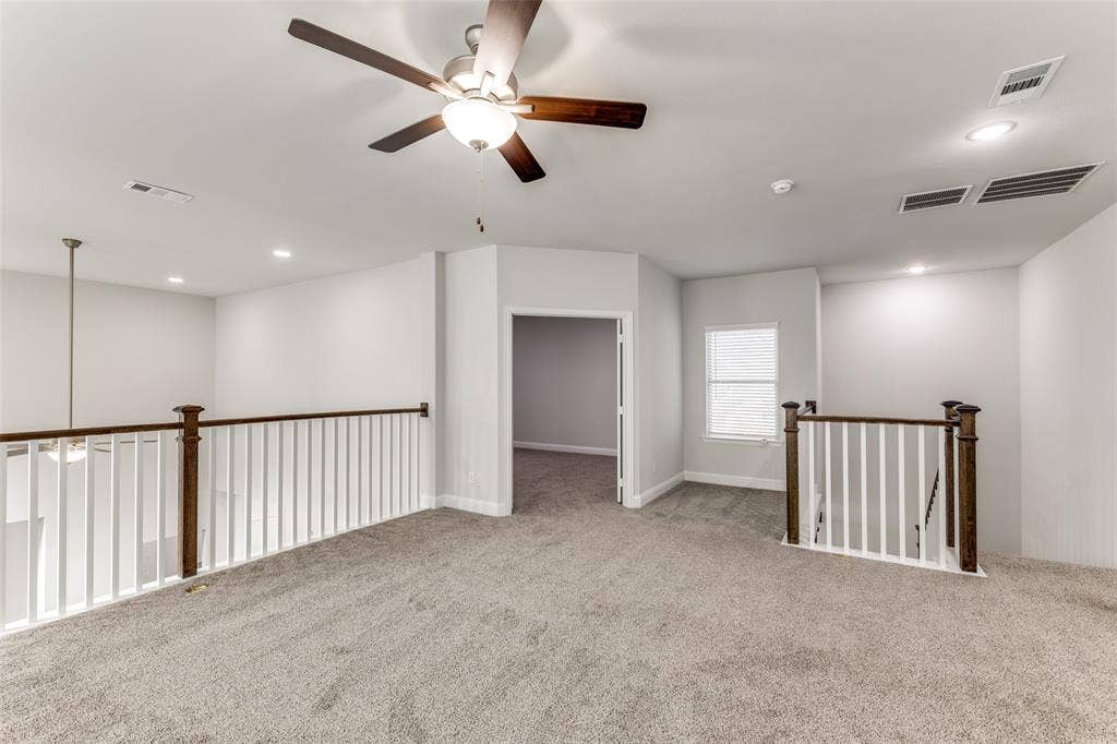Carpeted empty room featuring a ceiling fan and recessed lighting