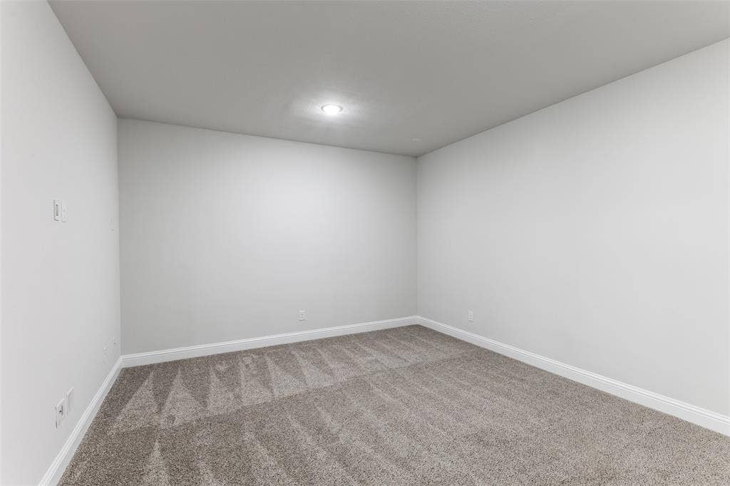 Carpeted empty room with baseboards