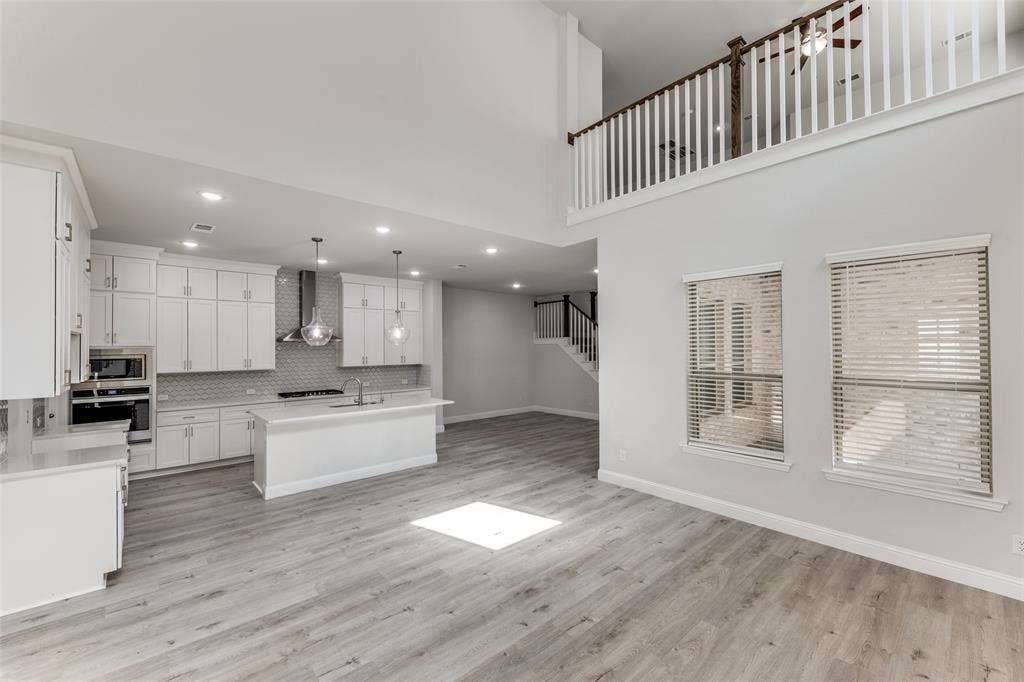 Kitchen with wall chimney exhaust hood, stainless steel appliances, a sink, decorative backsplash, and recessed lighting