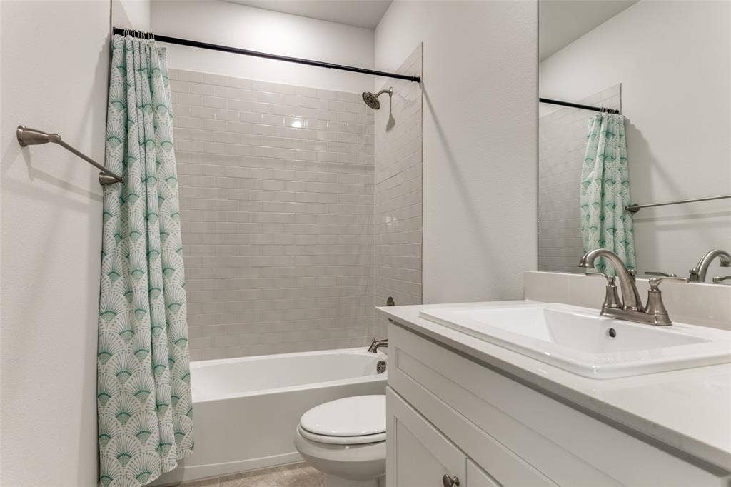 Bathroom featuring vanity, toilet, and shower / tub combo