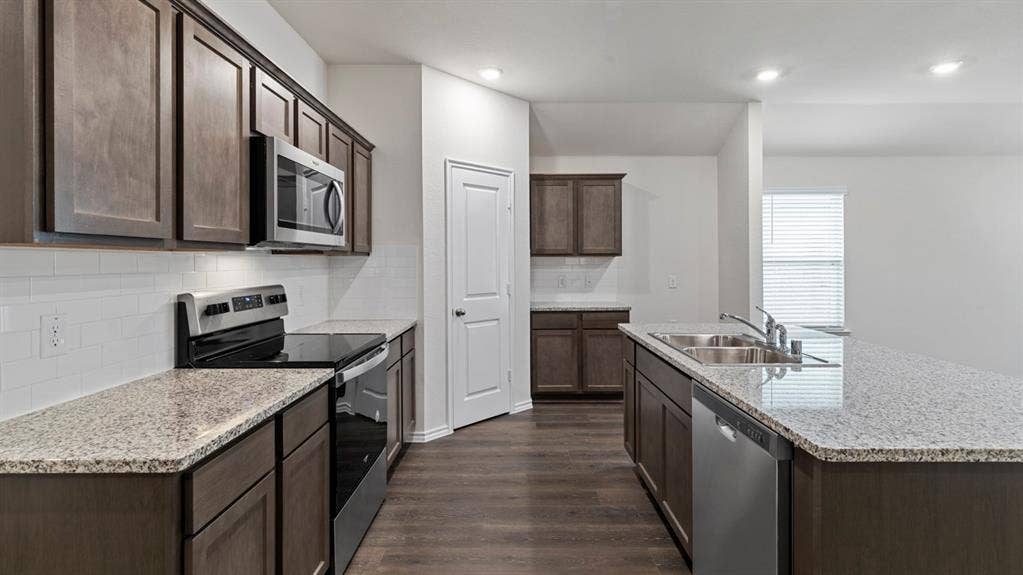 4028 Ripplewood Drive, Lindale, TX 75771 Kitchen featuring wood-finish flooring, granite countertops, stainless steel appliances, a subway tile backsplash, and recessed lighting