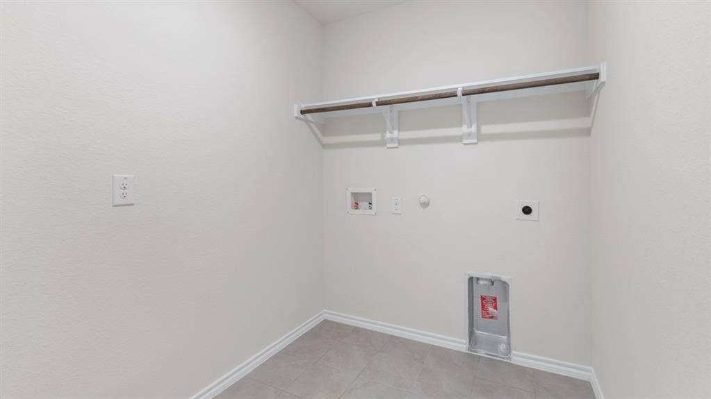 4028 Ripplewood Drive, Lindale, TX 75771 Laundry area featuring a hanging rod, wall-mounted shelf, and tile flooring