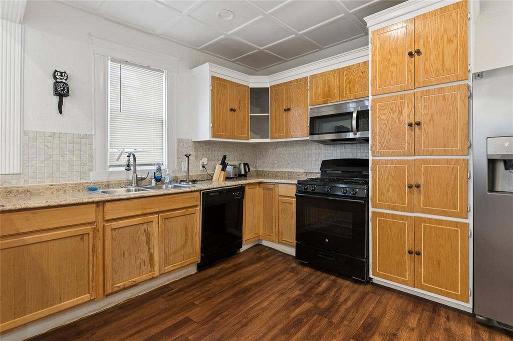 4112 Congress Avenue, Dallas, TX 75219 Kitchen featuring wood-finish cabinetry, granite-style countertops, stainless steel appliances, and wood-finish flooring