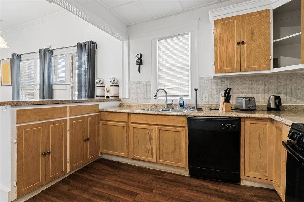4112 Congress Avenue, Dallas, TX 75219 Wood-finish flooring, light wood cabinetry, stone-finish countertops, tile backsplash, and a stainless steel sink