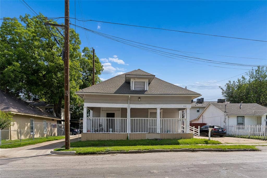 4112 Congress Avenue, Dallas, TX 75219 Pitched roof with dormer window, covered porch with white columns and railing, light-colored exterior siding, street-facing grass area, and a paved driveway