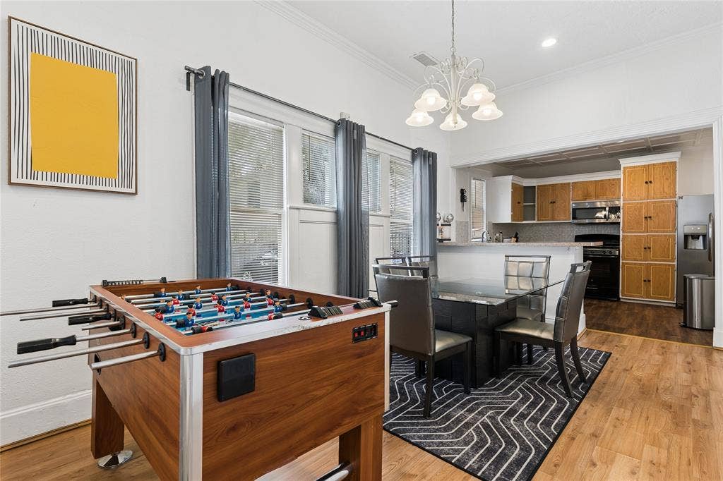 4112 Congress Avenue, Dallas, TX 75219 Wood-finish flooring throughout, with a dining area featuring a chandelier and direct sight to the kitchen