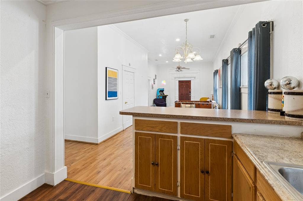 4112 Congress Avenue, Dallas, TX 75219 Wood-finish flooring throughout, light wood cabinetry with dark hardware, a built-in kitchen sink, and a durable countertop