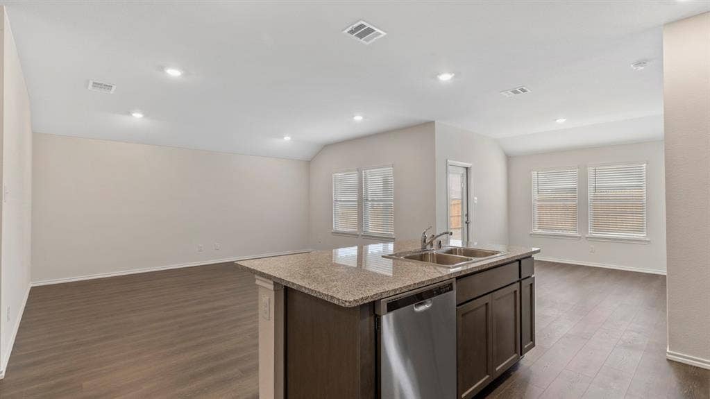 3037 Hidden Valley Drive, Lindale, TX 75771 Kitchen island with stone countertop, double stainless steel sink, and integrated dishwasher