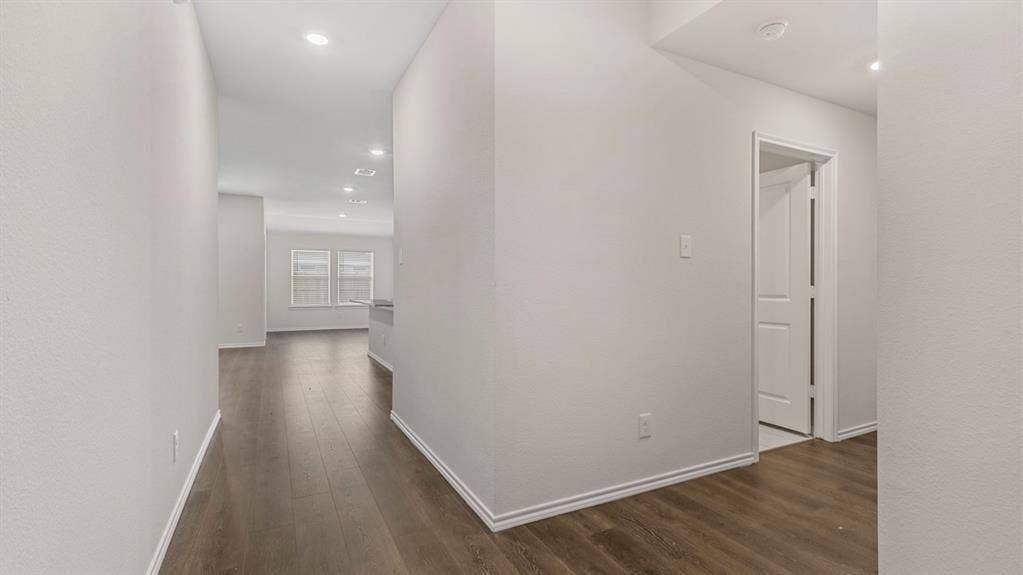 3037 Hidden Valley Drive, Lindale, TX 75771 Recessed lighting illuminates the hallway, featuring wood-finish flooring and light-toned walls