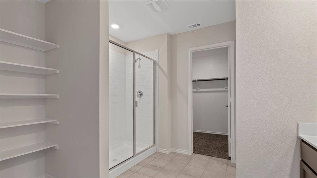 3037 Hidden Valley Drive, Lindale, TX 75771 Built-in shelving, glass-enclosed shower with subway tile surround, and tile flooring