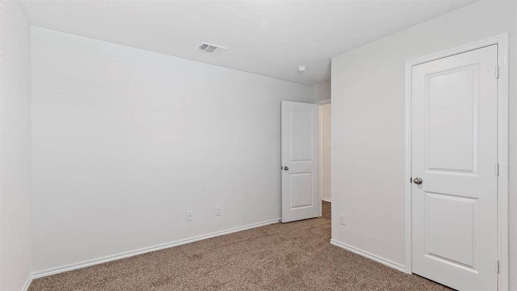 3037 Hidden Valley Drive, Lindale, TX 75771 Neutral tone wall paint, textured carpet flooring, white trim, and white panel doors