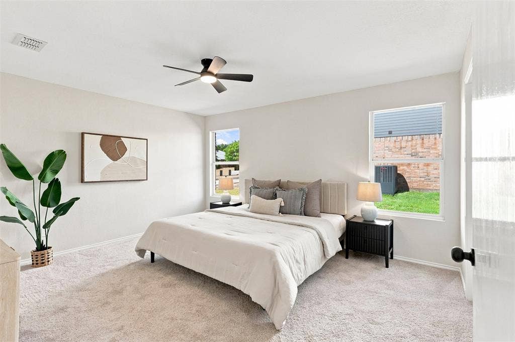 1406 Quail Meadow Drive, Wylie, TX 75098 Light-toned carpeting, two large windows, and a ceiling fan with integrated lighting