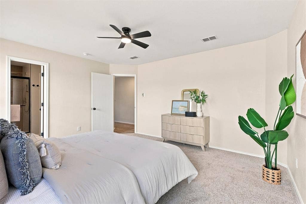 1406 Quail Meadow Drive, Wylie, TX 75098 Carpeted flooring, a ceiling fan with integrated lighting, and an adjacent bathroom with a glass-enclosed shower