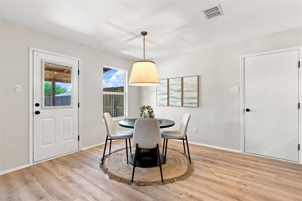 1406 Quail Meadow Drive, Wylie, TX 75098 Wood-finish flooring, white paneled door with a glass insert, additional white door, single hung window, and a drum pendant light