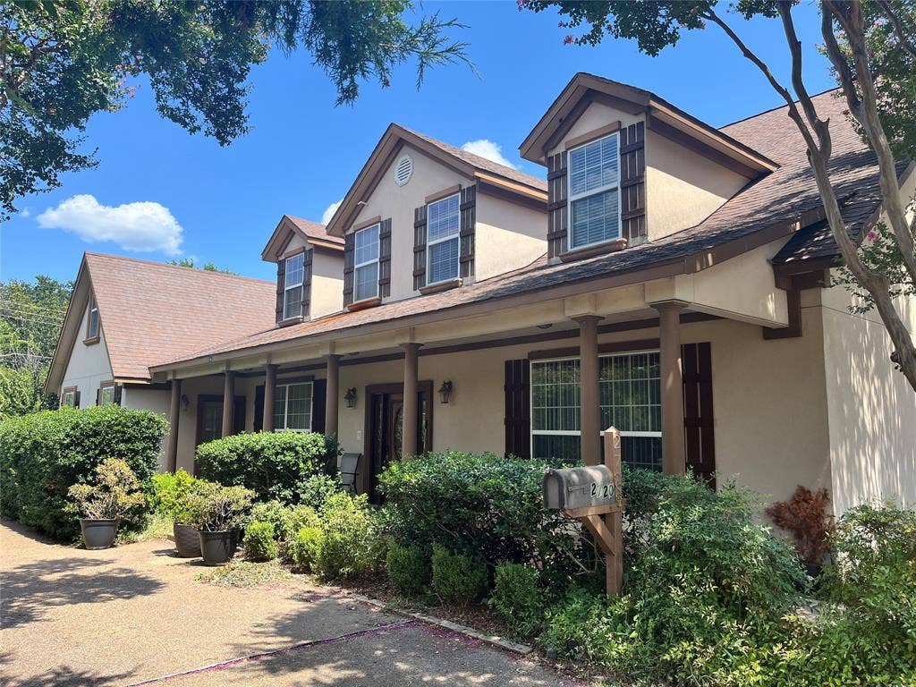 2720 Oates Drive, Mesquite, TX 75150 Pitched rooflines, multiple dormer windows, exterior shutters, covered front porch with pillars, and mature landscaping