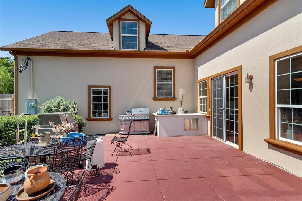 2720 Oates Drive, Mesquite, TX 75150 Expansive patio featuring a built-in outdoor kitchen, sliding glass doors, and stucco exterior with brown trim