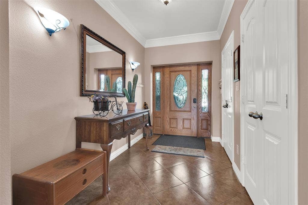 2720 Oates Drive, Mesquite, TX 75150 Entryway featuring tile flooring, a wood-paneled door with decorative glass inserts, and crown molding
