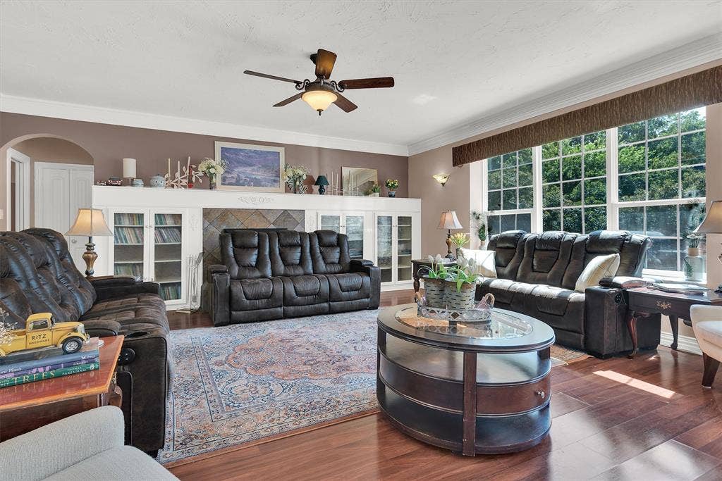 2720 Oates Drive, Mesquite, TX 75150 Spacious living area featuring wood-finish flooring, a ceiling fan, crown molding, and a large window wall