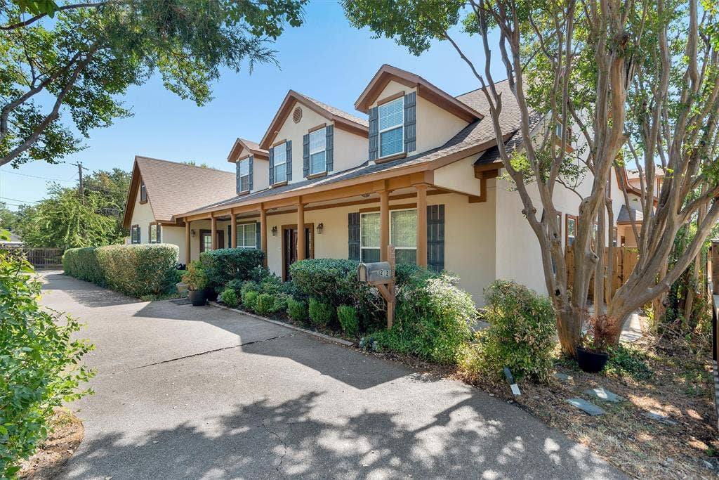 2720 Oates Drive, Mesquite, TX 75150 Two-story residence featuring dormer windows, a covered front porch with supporting columns, and a driveway