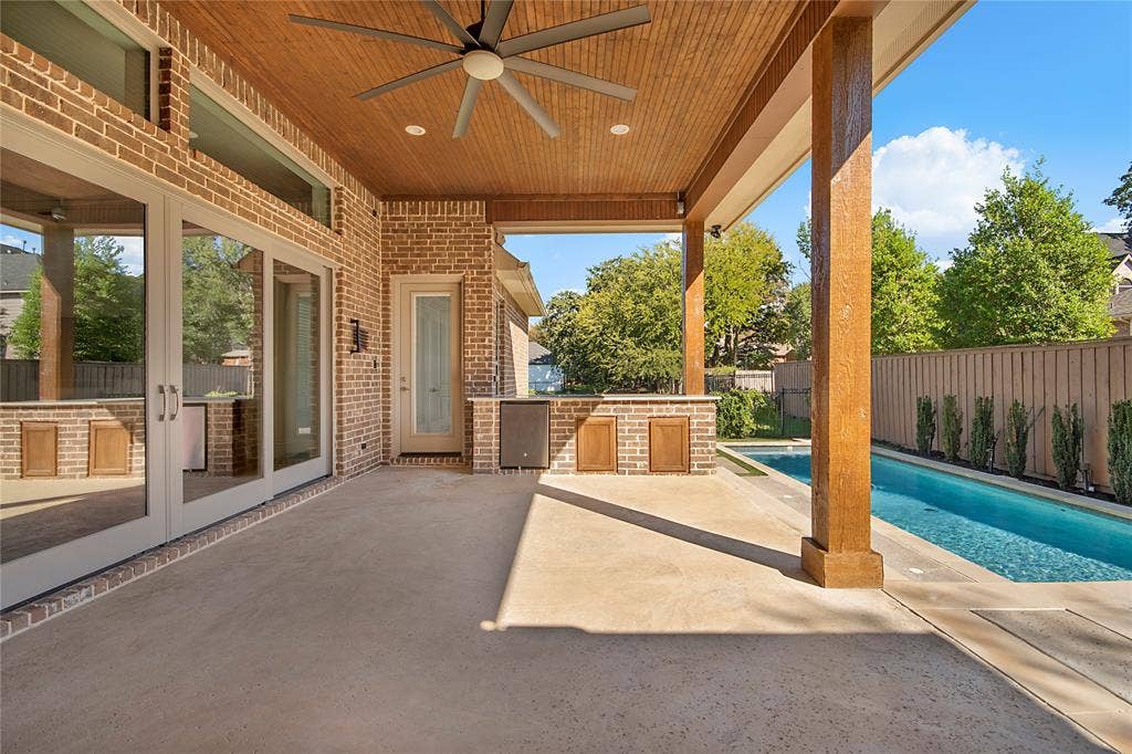Covered outdoor patio with a wood-plank ceiling and ceiling fan