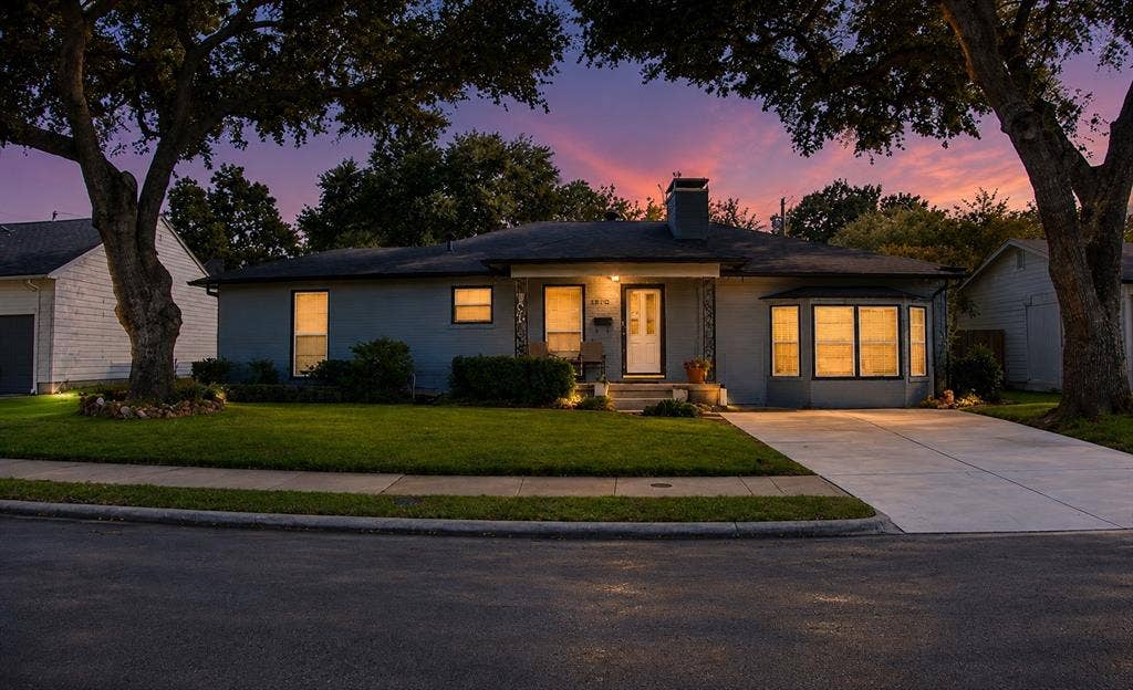 5012 Wateka Drive, Dallas, TX 75209 Single-story residence featuring a front entry, bay window, concrete driveway, and mature landscaping