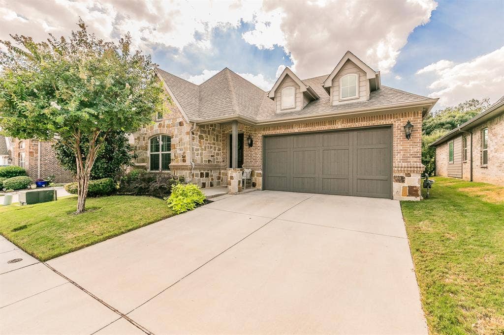 313 Elkhorn Trail, Keller, TX 76248 Stone and brick exterior featuring a multi-gable roofline and an attached two-car garage