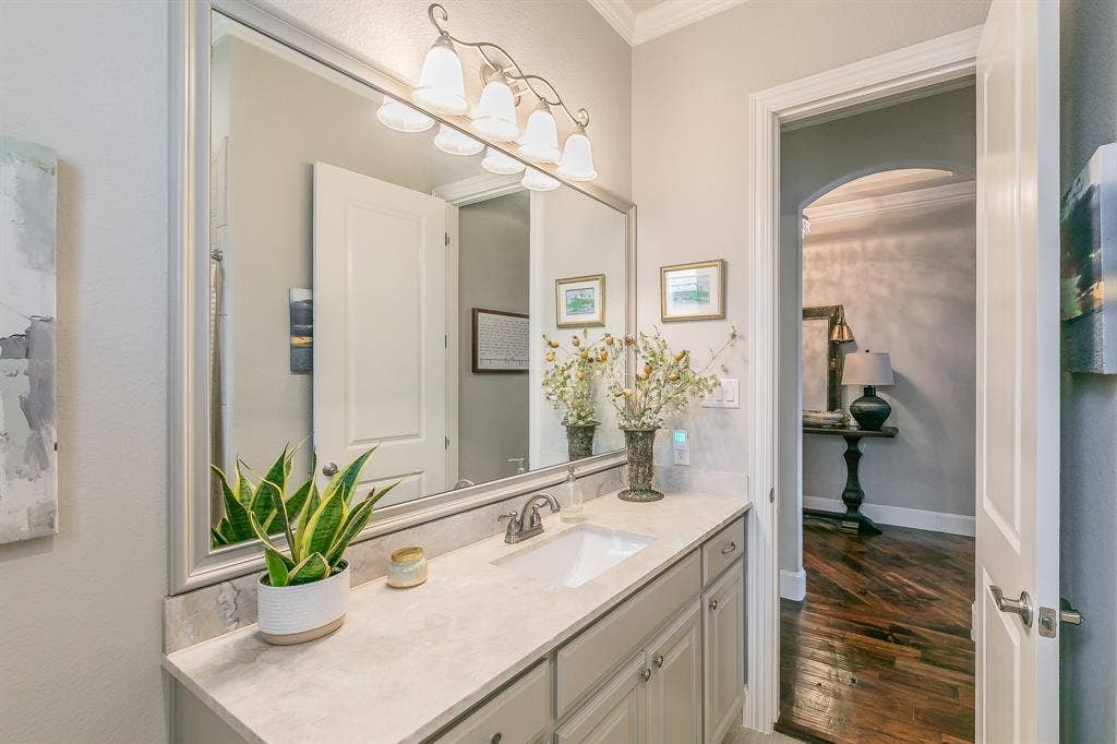 313 Elkhorn Trail, Keller, TX 76248 Vanity with an integrated sink and light-colored countertop, framed mirror, and a four-light vanity fixture