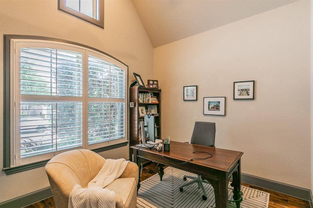 313 Elkhorn Trail, Keller, TX 76248 Wood-finish flooring, vaulted ceiling, arched window with plantation shutters, and a built-in wood bookshelf
