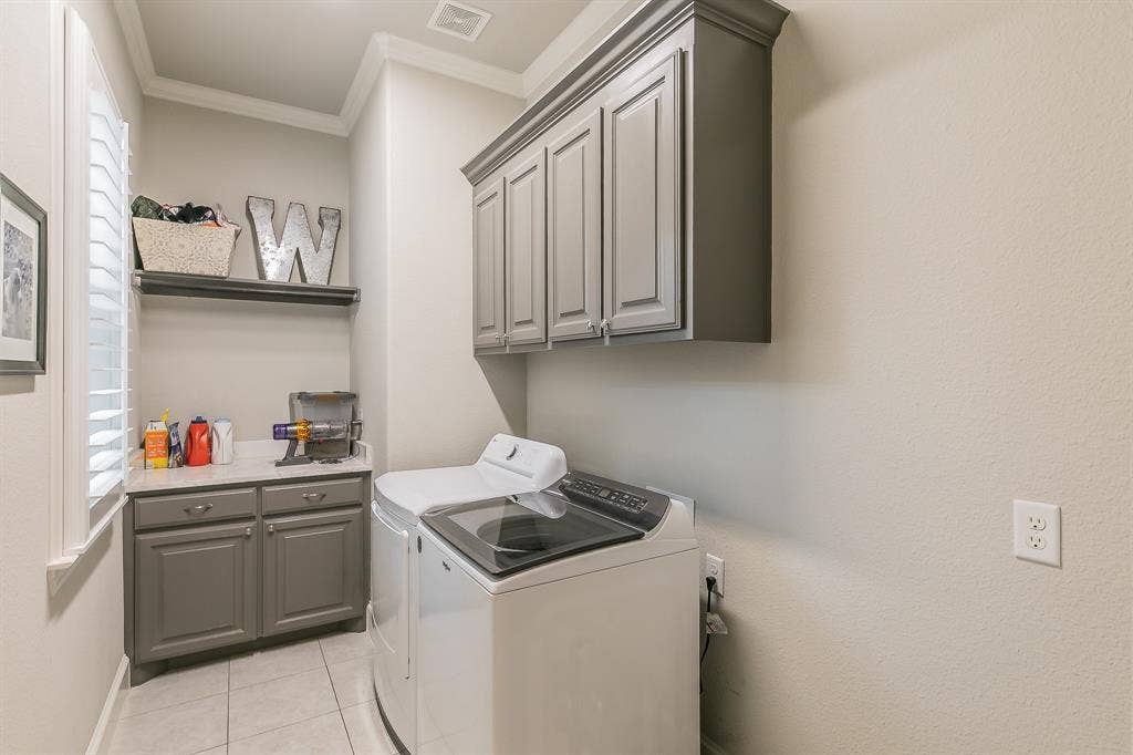 313 Elkhorn Trail, Keller, TX 76248 Laundry room featuring gray shaker-style cabinetry, a white countertop, and tile flooring