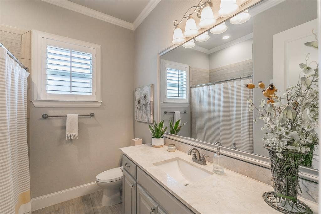 313 Elkhorn Trail, Keller, TX 76248 Bathroom featuring a single vanity with a solid surface countertop, an undermount sink, and wood flooring