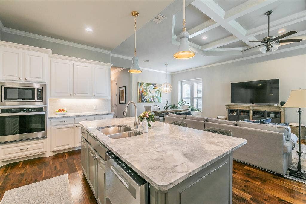 313 Elkhorn Trail, Keller, TX 76248 Kitchen featuring a large island with an undermount sink, stainless steel appliances, and white cabinetry