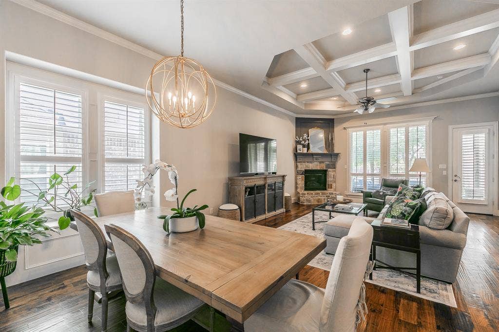 313 Elkhorn Trail, Keller, TX 76248 Rich wood-finish flooring throughout, featuring a stone-clad fireplace, coffered ceiling, and plantation shutters