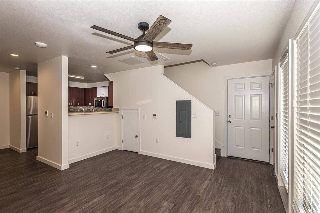 3022 Forest Lane, #116, Dallas, TX 75234 Living room with ceiling fan,wood-style flooring, and storage under staircase