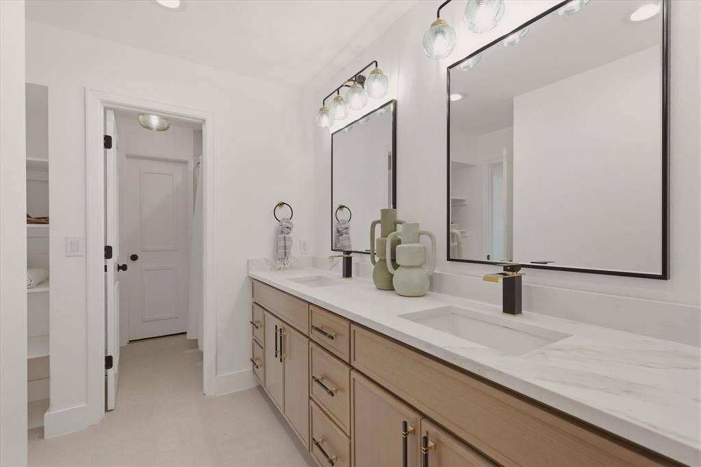 Dual vanity with wood-finish cabinetry, integrated rectangular sinks, and white countertops