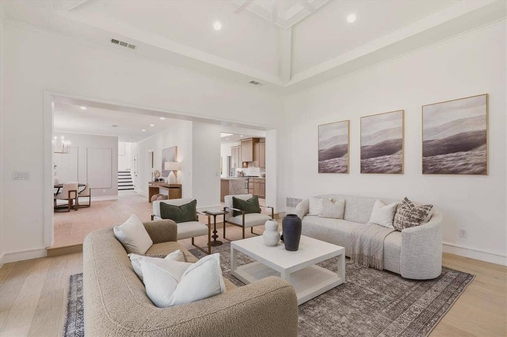 Vaulted tray ceiling, recessed lighting, wood-finish flooring, open archway, and neutral wall tones